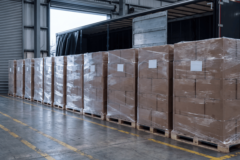 A row of machine-wrapped pallets waiting at a loading bay