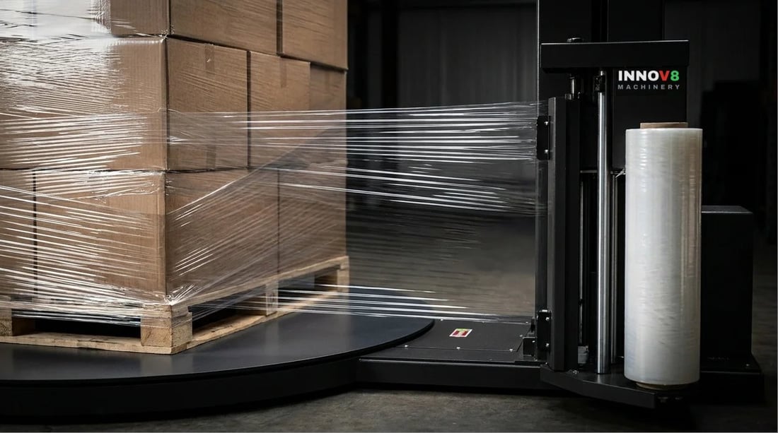 An INNOV8 pallet wrapper carriage stretch wrapping a pallet of cartons