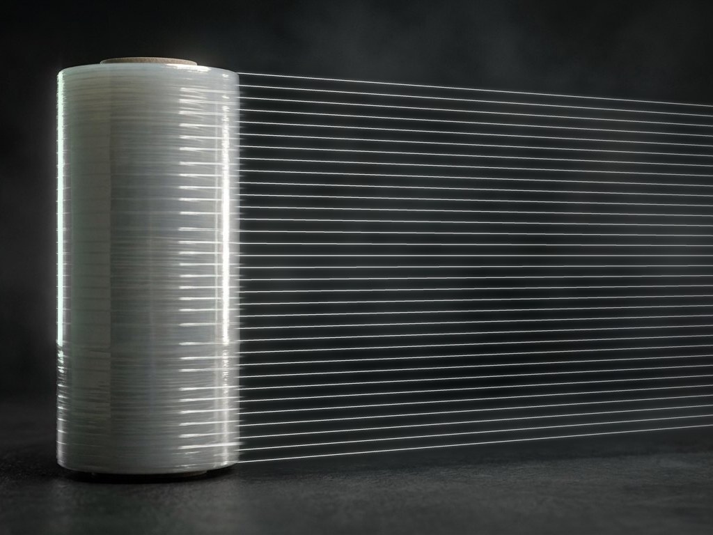 A roll of FiberFilm reinforced stretch film, with its reinforcing strands running through the film